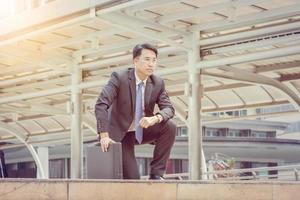 Business man kneeling with suitcase, start up concept. photo