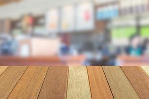 Empty wooden table top perspective with blur coffee shop background, used for montage or display your products. photo
