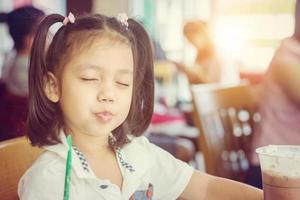 little cute girl drinking iced chocolate in coffee shop, Happy and enjoy kid concept. photo