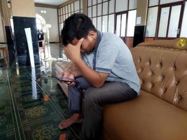 kasongan, indonesia. 2022. un hombre está sentado y sosteniendo su cabeza foto