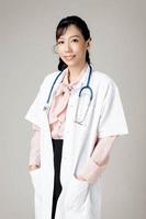 Portrait of an attractive young female doctor in white coat. photo