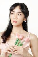 la mujer asiática con una cara hermosa y una piel fresca y suave está vestida de rosa. foto