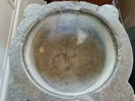 heavy grey stone baptismal font or basin for baptism photo