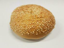 sesame seed bagel on white surface or table photo