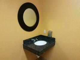 yellow wall in restroom or bathroom with sink and mirror photo