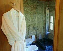white bath robe and toilet and shower in bathroom photo