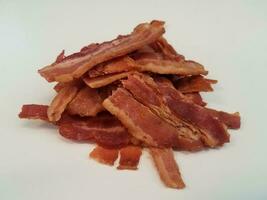 pile or mound of bacon strips on white surface photo