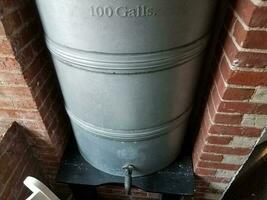 metal 100 gallon container or barrel and bricks photo