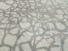 cracks and lines in damaged black asphalt or pavement photo