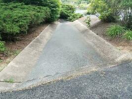 asphalt and cement gutter with drain grate photo