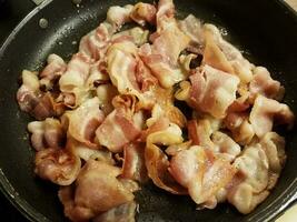 bacon cooking in frying pan or skillet photo