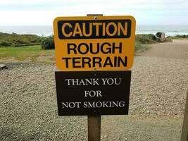 yellow caution rough terrain thank you for not smoking signs photo