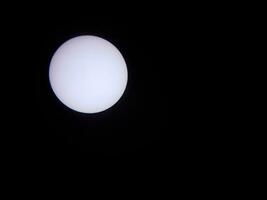 sol a través de un filtro solar y un telescopio con el planeta mercurio foto