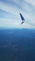 airplane flying with mountains and landscape and clouds photo