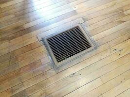 air vent or register in brown wood floor photo