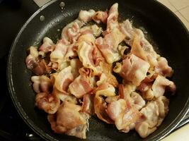 bacon cooking in frying pan or skillet photo