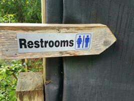 wooden restroom sign with arrow photo