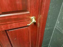 dark brown and red door with handle in bathroom photo