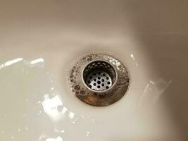 bathroom sink with drain and water and soap bubbles photo