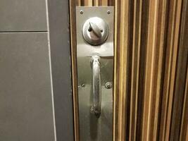 wood bathroom door with broken metal lock and handle photo