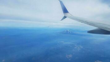 airplane flying with mountains and landscape and clouds photo