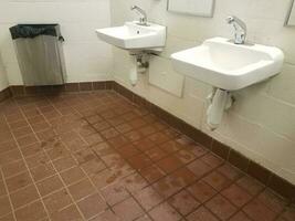 bathroom sinks with wet and slippery tile floor photo