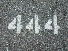 el número 444 pintado sobre asfalto negro foto