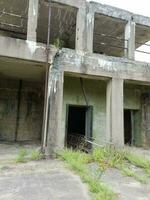 old abandoned cement building with weeds photo