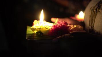 mão de menina indiana segure a lâmpada de vela com flor video