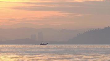 vissersboot bewegen op zee in gouden ochtend.