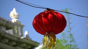 Red lantern blow by wind under blue sunny day. video