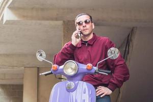 Young stylish male with colorful motor scooter photo