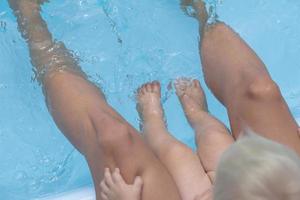 happy family having good time in blue swimming pool photo