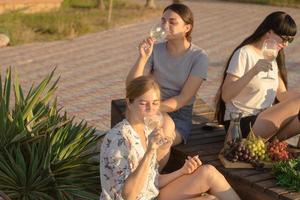 Summer party of young beautiful womans with wine, sea resort relaxing in sunny day photo