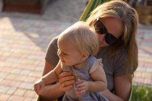 Young mother relaxing with daughter in hammock on the beach photo