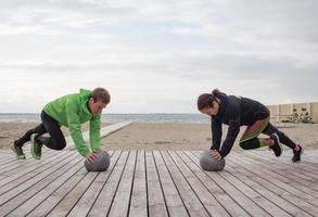 group of young people training outdoors, runners exercises, sea or river background photo