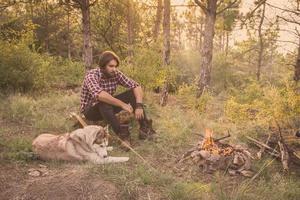 joven viajero masculino con perro husky foto