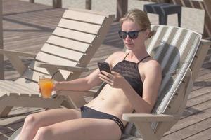 young blonde woman relaxing in the blue pool, summertime vacation photo