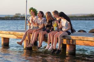 fiesta de verano de jóvenes hermosas mujeres con vino, balneario relajante en un día soleado foto