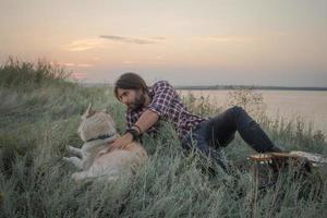 joven viajero masculino con perro husky foto