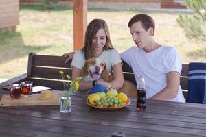 Young couple with beagle dog, happy family have good time in backyard photo