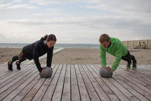 group of young people training outdoors, runners exercises, sea or river background photo