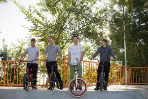 Group of young people with bmx bikes in skate plaza, stunt bicycle riders in skatepark photo