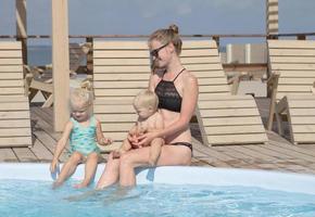 happy family having good time in blue swimming pool