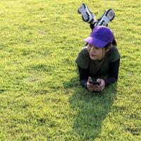Woman wearing a cap, resting on a lawn. photo