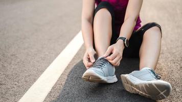 closeup of young woman runner tying her shoelaces. healthy and fitness concept. photo