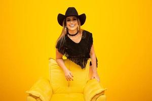 Happy sexy cowgirl on yellow background photo