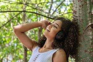 Beautiful afro american girl listening music in a park photo