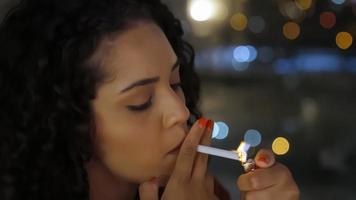 una chica latina triste fuma tarde en la noche. foto