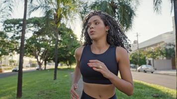 Latin woman runner running in city street. Female jogger training. Active healthy lifestyle. photo